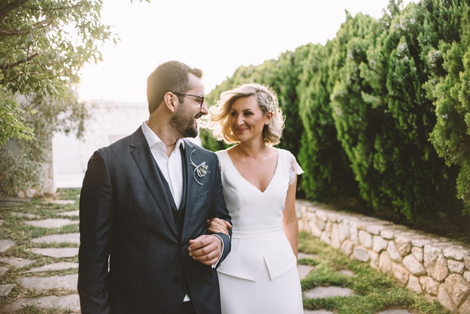 A wedding couple walking hand in hand - Ktima Gregou, Athens, Greece photography. Ktima Gregou, Athens, Greece couple walking hand in hand happy on wedding day.