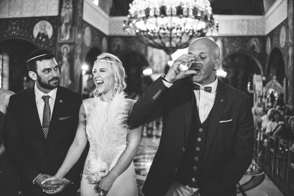 Varobopi, Greece wedding photo of groomsmen drinking wine Photo of groomsmen drinking wine during the wedding ceremony in Varobopi, Greece