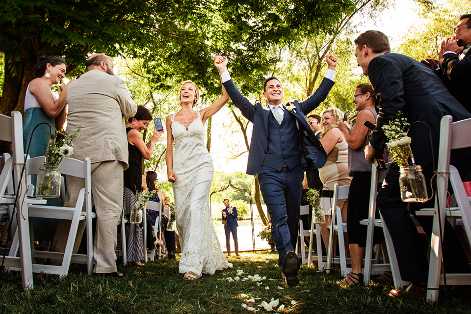 The Farm at Eagles Ridge, Lancaster PA - Outdoor Wedding Ceremony Photography Bride and Groom exit the ceremony happily holding hands outside The Farm at Eagles Ridge, Lancaster PA