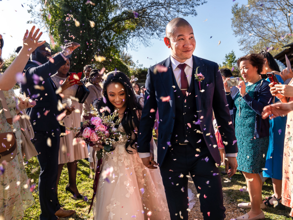 La sposa e lo sposo sono accolti da una cerimonia all'aperto di coriandoli doccia presso l'Hertfordshire foto di matrimonio di coriandoli lanciati a Minstrel Court, North Road, Royston, Hertfordshire, Regno Unito Foto di matrimonio dell'Hertfordshire di coriandoli lanciata a Minstrel Court, North Road, Royston, Hertfordshire, Regno Unito