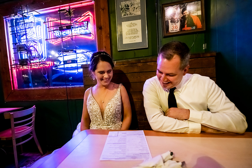 Foto de Red Cliff Colorado Elopement da noiva e do noivo em uma festa de recepção para dois em um restaurante Noivos do Colorado jantando em um restaurante-bar após fugir