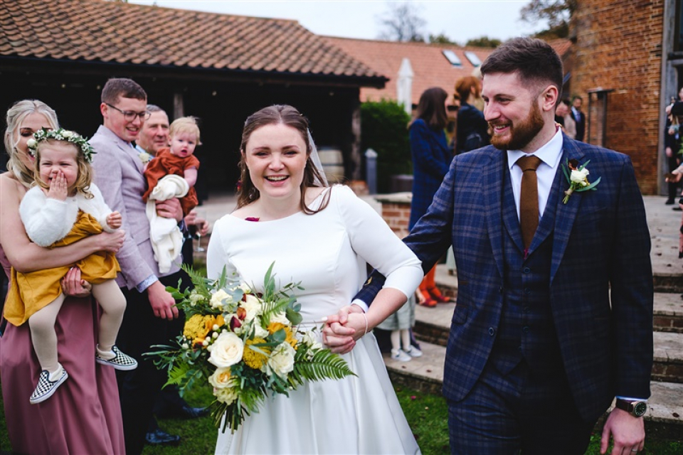 Les mariés félicités par leurs invités au lieu de mariage de Norfolk, Southwood Hall Les mariés marchent bras dessus bras dessous parmi leurs invités à leur réception de mariage à Southwood Hall, Norfolk