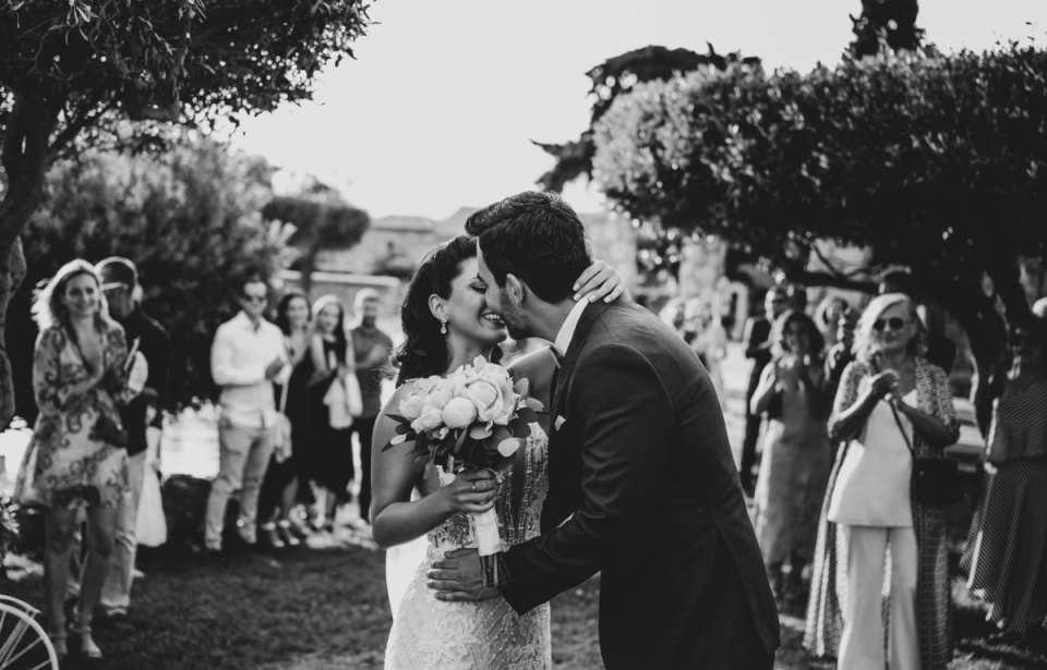 Black and white wedding picture of the bride and groom kissing at Melissourgos Tower, Attica, Greece Melissourgos Tower, Attica, Greece wedding image of the bride and groom kissing outdoors