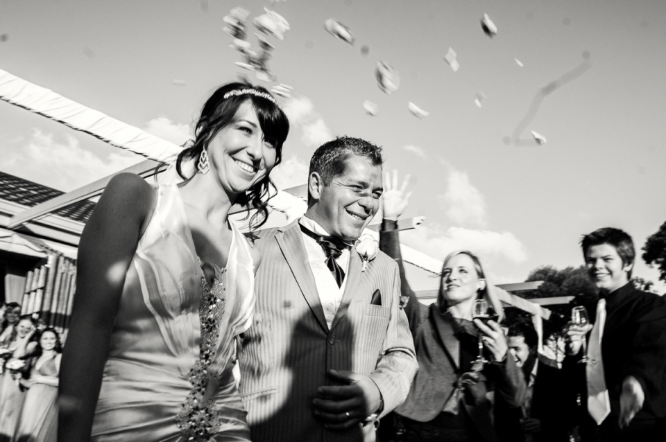 New Zealand wedding ceremony celebration photography New Zealand black and white wedding ceremony celebration image of thrown flower petals over the bride and groom