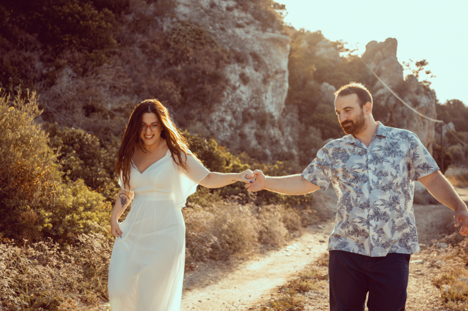 Outdoors in the sunshine wedding image of the bride and groom walking a trail at Varkiza Resort, Attica, Greece Varkiza Resort, Attica, Greece wedding picture of the bride and groom walking hand in hand along a trail