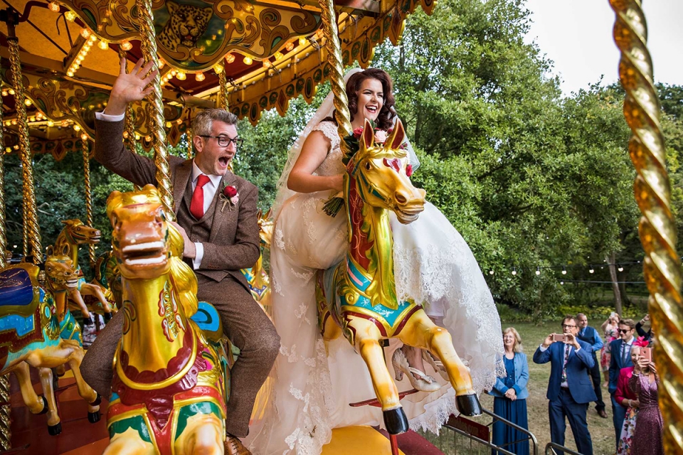 Aaron Storry | Northamptonshire wedding photographer for East Midlands The bride and groom ride carousel horses | wedding photography at the West Green House, Hampshire, United Kingdom