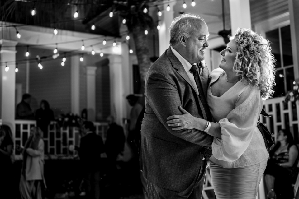 A black and white picture from a French Quarter wedding reception party of a Louisiana couple taking on the dance floor A New Orleans bride and groom share a dance together during their French Quarter wedding reception in Louisiana