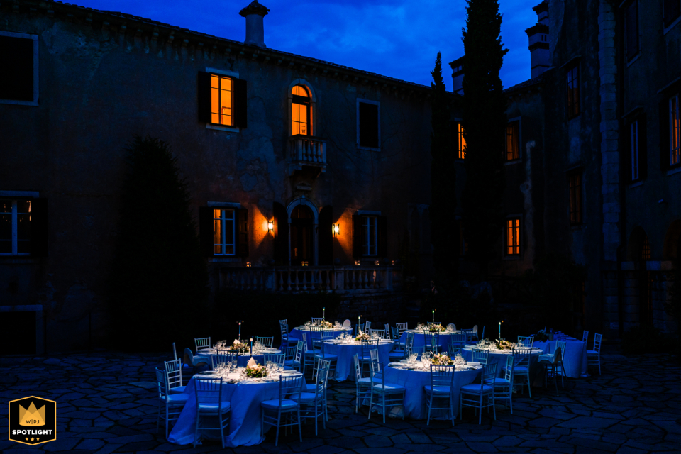 Tables Set in Garden During Blue Hour at Castello di Duino At Castello di Duino in Duino, Trieste, Italy, tables are elegantly set in the castle garden during the enchanting blue hour, creating a dramatic atmosphere for the event.