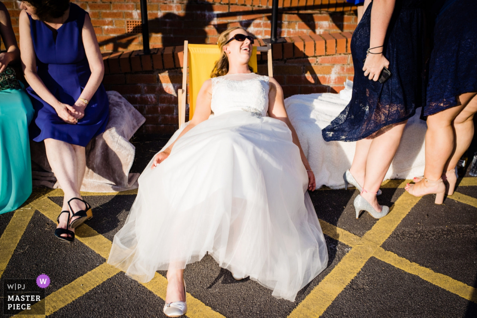 Bride sits down in her dress at the wedding at the Silverdale Village Hall