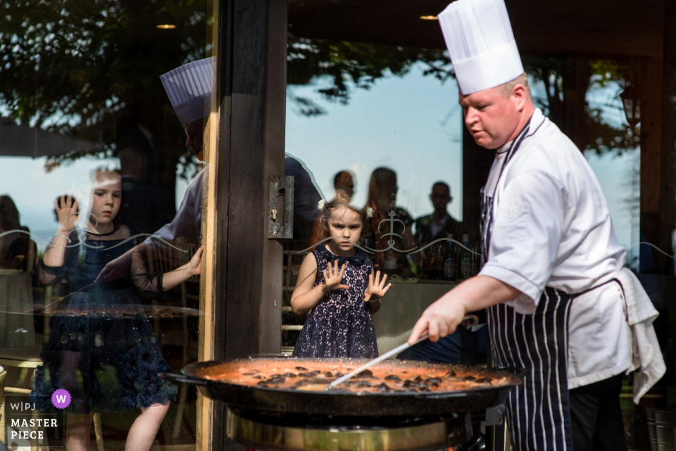 Foto von: <a href="https://www.wpja.com/contests/2018-v11/best-wedding-photographers/2262716"> Helen Batt - Ashford Kent </a> Chefkoch bereitet Paella für Hochzeitsgäste vor Chef bei Crown Lodge Hochzeit in Kent