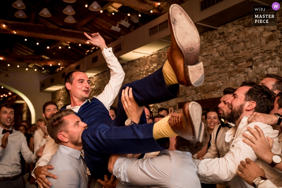 Seigneurie du Bois Benoist Bruiloft Foto van de bruidegom die door vrienden is opgetild bij de receptie