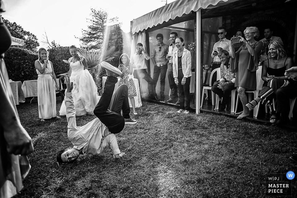 a young break dancing guest on the grass Antico Casale Borgofranco wedding photograph of break dancing guest on the grass.