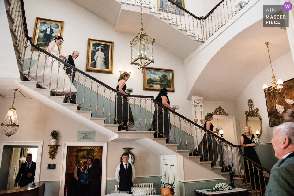 Melville Castle, Edinburgh, Escócia Fotografia de casamento das damas de honra, noiva e pai descendo as escadas