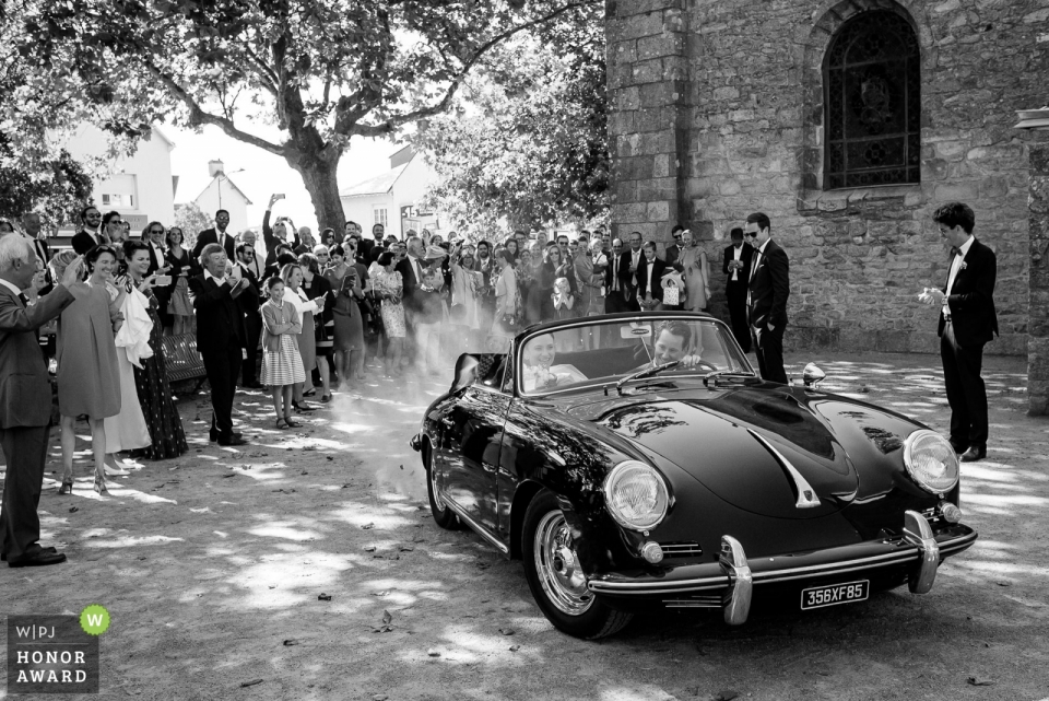 Domaine de la Bretesche trouwfoto van echtpaar dat vertrekt in vintage cabriolet | huwelijksfotografie