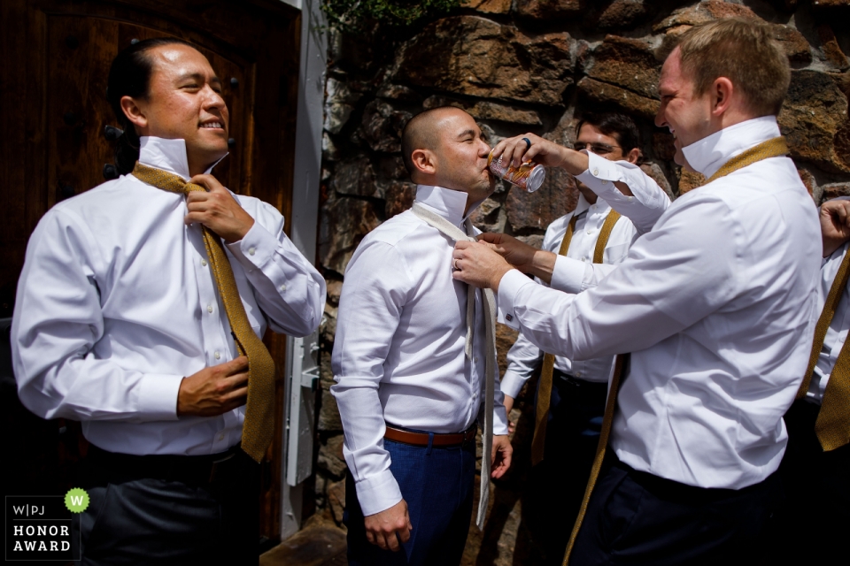 Foto: <a href="https://www.wpja.com/contests/2018-v19-Fotografie-wettbewerb/best-wedding-photographers/2380491"> Travis Haughton - Chicago Illinois </a> Hochzeitsfotojournalismusbild des Bräutigams und der Trauzeugen, die ihre Bindungen an der Rotwild Creek Valley Ranch tun