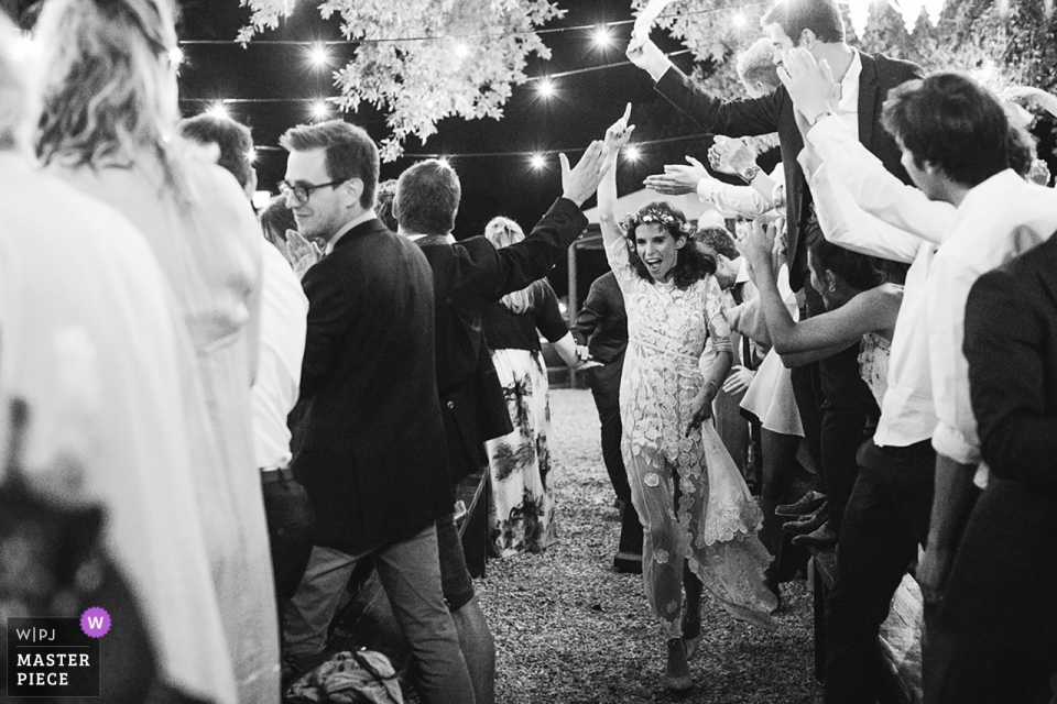 Foto por: <a href="https://www.wpja.com/contests/2019-v01/best-wedding-photographers/2422701"> Alessandro Serravalle - Pisa Pisa </a> Villa Orlando, Torre del Lago, fotografía de boda de Lucca en blanco y negro de la novia caminando a través de los invitados mientras celebran