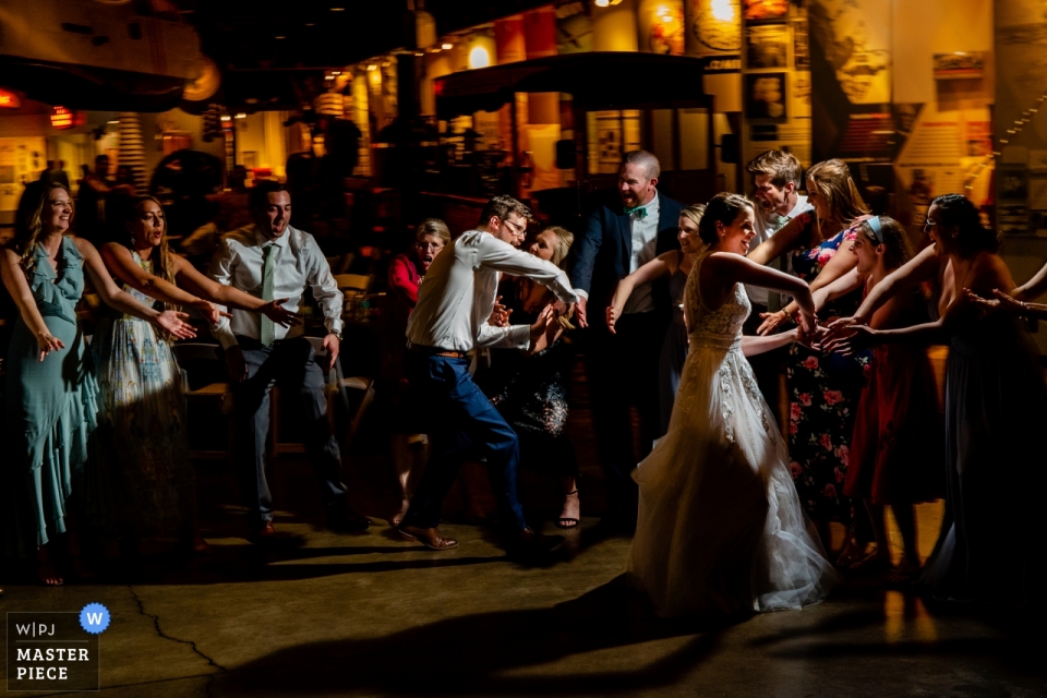 Photo by: <a href="https://www.wpja.com/contests/2019-v02/best-wedding-photographers/2448021">Johnny Shryock - Arlington Virginia</a> Baltimore Museum of Industry, Baltimore, MD wedding photographer | High fives and low fives for the married couple on the reception dance floor.