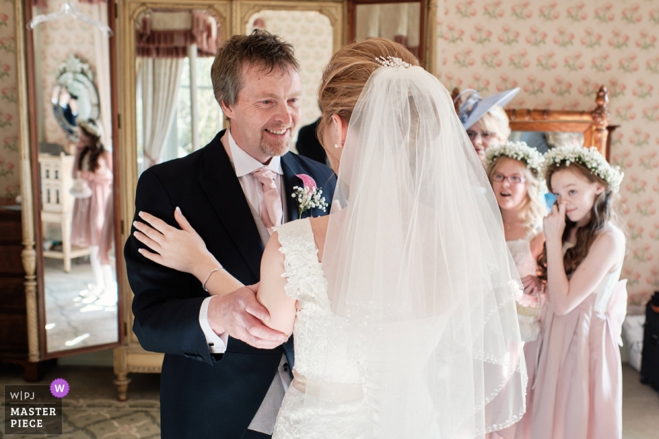 Foto: <a href="https://www.wpja.com/contests/2019-v03/best-wedding-photographers/2456441"> Ian Bursill - Loughborough Leicestershire </a> Kilworth House, Leicestershire, UK Hochzeitsfotografie | Papas erster Blick auf seine Tochter, die Braut, nachdem sie sich fertig gemacht hat
