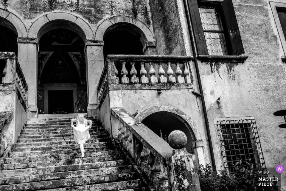 Foto der Tochter von Braut und Bräutigam, die die große Treppe hinaufsteigt Villa Godi Malinverni Foto der Tochter von Braut und Bräutigam, die die große Treppe hinaufsteigt.
