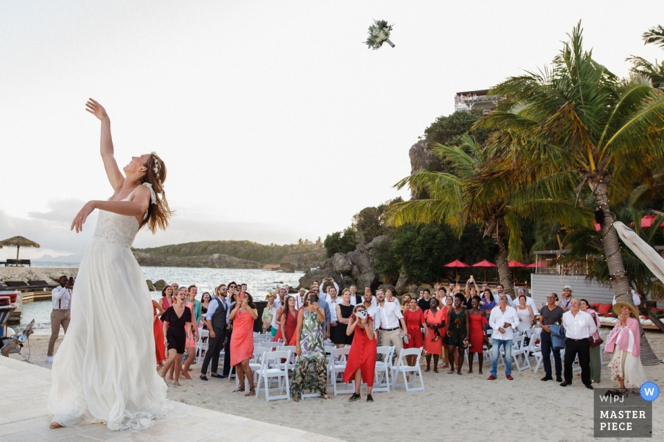 La Toubana - fotografia de dia de casamento de Guadalupe do buquê lançado pela noiva na praia