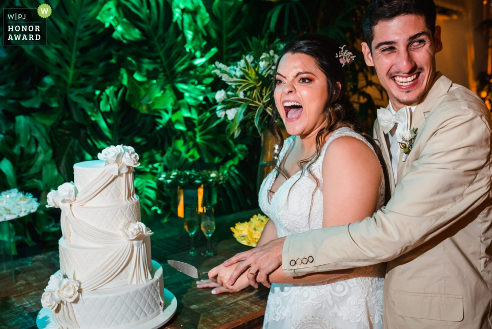 Caravelas Eventos - Botafogo | Bride and groom have  fun during the cake cutting at their reception