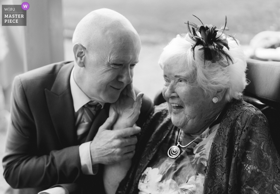 Foto: <a href="https://www.wpja.com/contests/2019-v05/best-wedding-photographers/2474131"> Roger Kenny - Greystones Wicklow </a> Der Dubliner Hochzeitsfotograf hat dieses Schwarzweißfoto eines zarten Moments mit Oma bei einer Zeremonie im Clonabreany House aufgenommen
