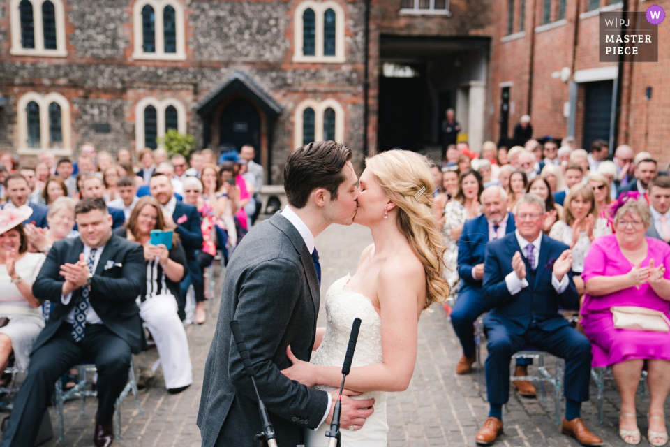 Bombay Sapphire Gin destilaria, Hampshire, Reino Unido fotografia de cerimônia de casamento - o primeiro beijo para a noiva eo noivo