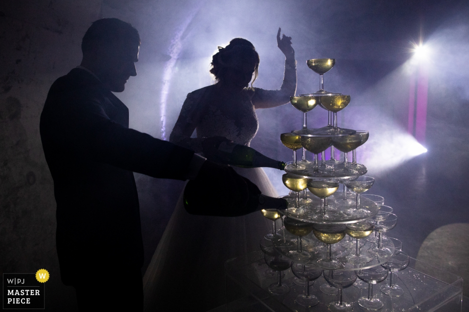 Wedding Reception Champagne Photo of the bride and groom pouring from the bottles into a tower of glasses. Chateau de Chapeau Cornu Wedding Reception Champagne time! | Photo of the bride and groom pouring from the bottles into a tower of glasses.