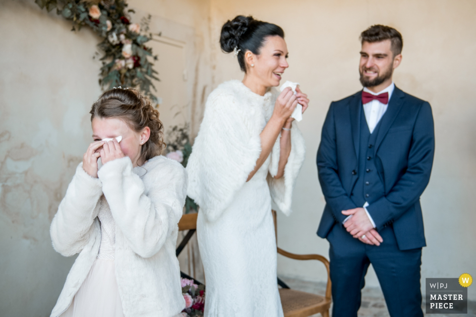 Ein Hochzeitsfotograf hat dieses Foto von der Braut und ihrer Tochter aufgenommen, die sich die Freudentränen abwischen, als sie vor ihrem Bräutigam steht Oise Hochzeitsfotograf hat dieses Foto der Braut und ihrer Tochter aufgenommen, die sich vor Freude die Tränen abwischen, als sie vor ihrem Bräutigam steht