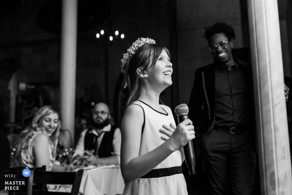 Foto: <a href="https://www.wpja.com/contests/2019-v05/best-wedding-photographers/2482956"> Esther Gibbons - Montreal Quebec </a> L'Ambroisie, Montreal, Quebec Hochzeitsfotograf | Bild des Blumenmädchens, das eine Rede während des Hochzeitsempfangs gibt