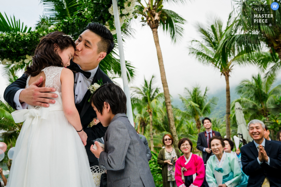 Photo by: <a href="https://www.wpja.com/contests/2019-v08/best-wedding-photographers/2513986">Khoi Le - Ho Chi Minh City </a> The groom hugs his children during his Da Nang wedding ceremony.