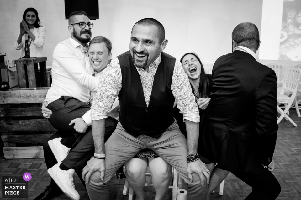 Guests playing a game and laughing during dinner at the Domaine de la Ruade wedding venue