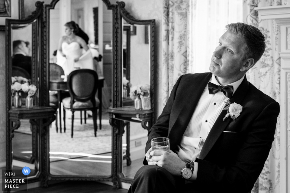 Foto door: <a href="https://www.wpja.com/contests/2019-v08/best-wedding-fotografen/2517141"> JD Land - Marlton New Jersey </a> Glencairn Mansion Trouwlocatiefotograaf - De bruidegom kijkt toe terwijl de bruid haar jurk bruist.