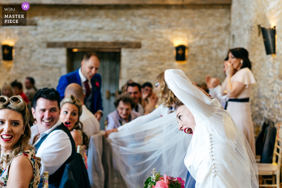 Fotógrafo del lugar de la boda de Oxleaze Barn Cotswolds - Cuando la pareja fue anunciada con el velo de la novia, el invitado atrapado en la silla - se produjo mucha conmoción / risa ...