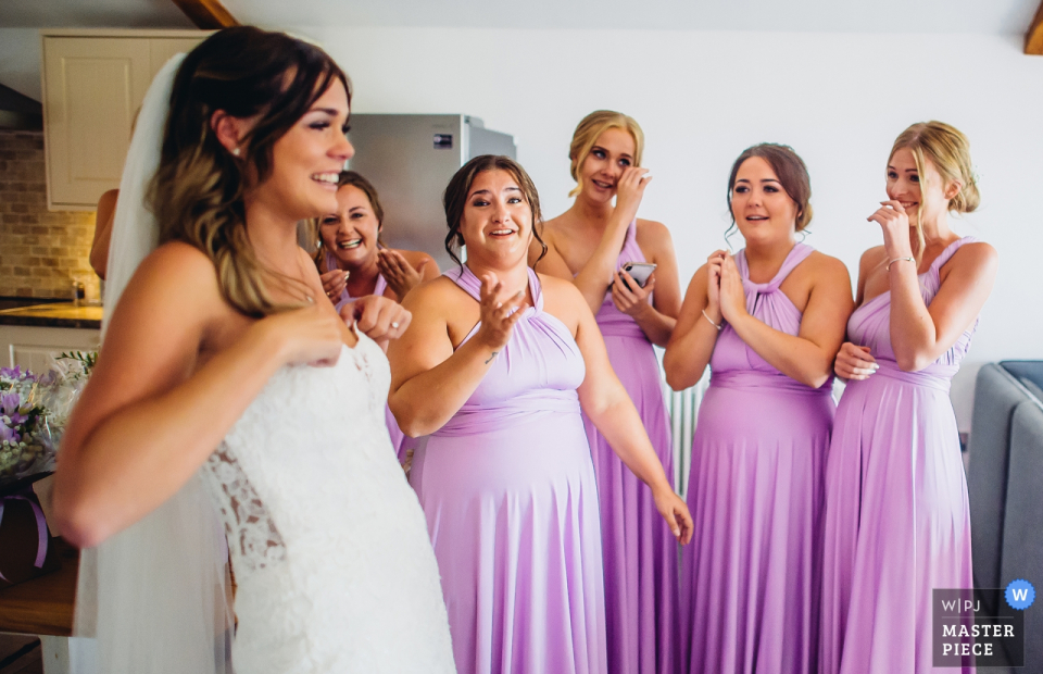 Bridesmaids take a first look at Bride in her dress at Quantock lakes