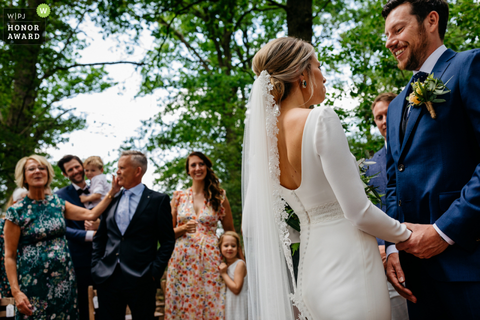 outdoor ceremony photo of the bride and groom holding hands Erfgoed Bossem outdoor ceremony photo