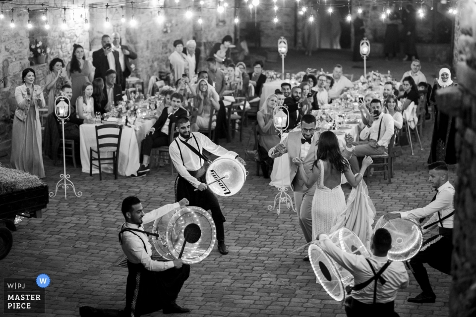 Fotografía de boda de Podere Conti Tuscany - Foto de novios bailando con músicos árabes tocando