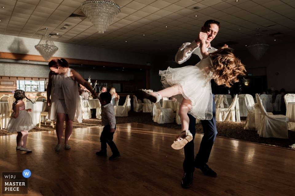 Bruiloft Receptie locatie fotografie: Royal Court Hotel, Portrush. - De bruidegom zwaait zijn dochter rond op de dansvloer