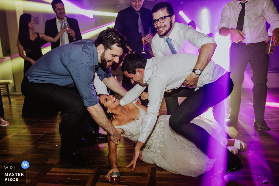 a fallen bride with guests and groom helping her up Porto Alegre, Casa da Figueira wedding photography of fallen bride with guests and groom helping her up.
