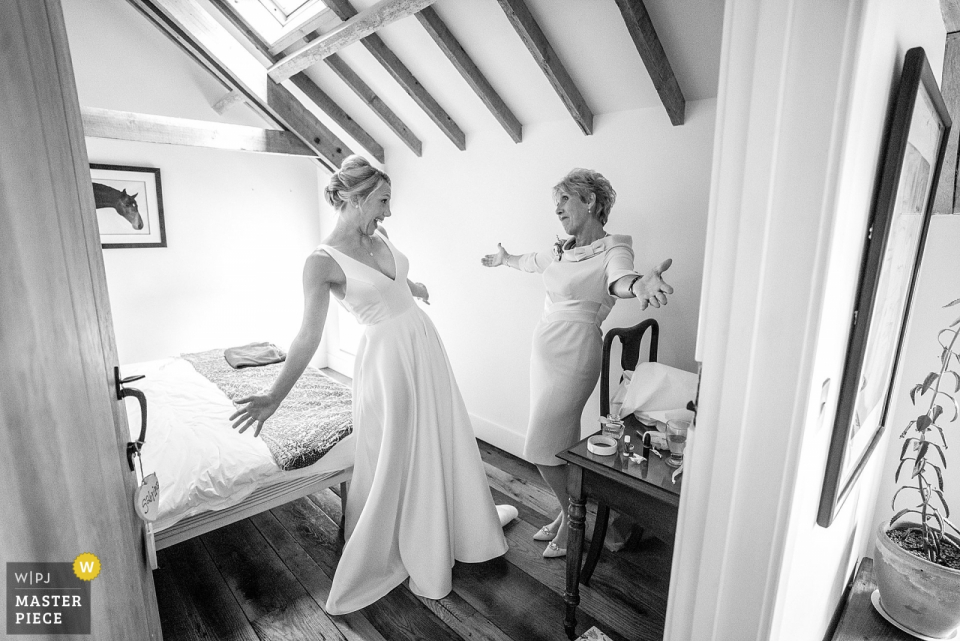 The bride & her mother open arms, ready to embrace. Preparations are complete, everything perfect & ready to head to the church for the wedding ceremony. in Hampshire, UK.