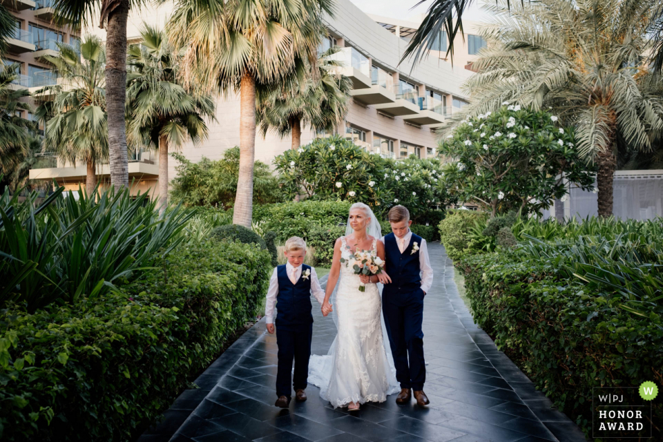 Rixos Hotel The Palm Dubai trouwlocatie beeld van de bruid die met haar zonen naar de ceremonie loopt