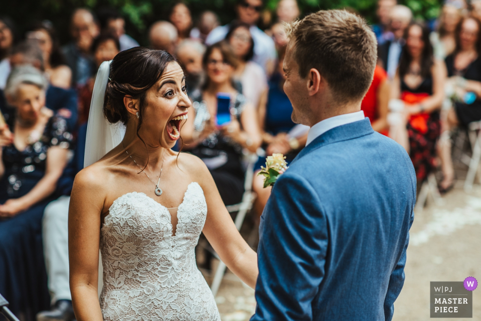 Photographie de lieu de mariage du Château de Roquelune, Pezenas, France | Une mariée réagit avec enthousiasme à la fin de sa cérémonie de mariage