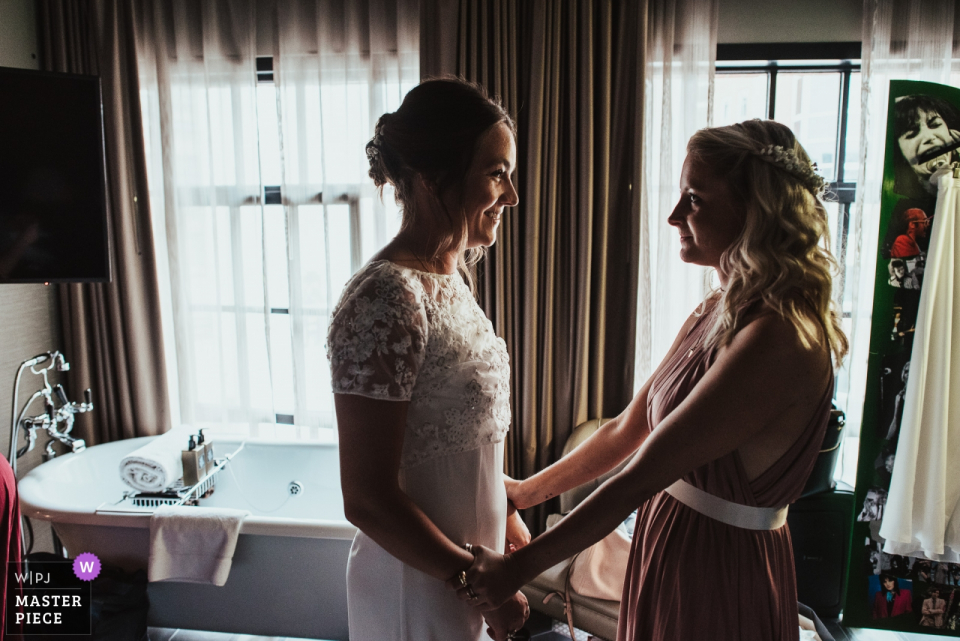 Foto von: <a href="https://www.wpja.com/contests/2019-v17/best-wedding-photographers/2564533"> Mark Wallis - Belper Derbyshire </a> The Curtain Hotel, Hackney, London - Hochzeitsfotos - Eine Braut wird vor ihrer Hochzeitszeremonie von ihrer Brautjungfer beruhigt