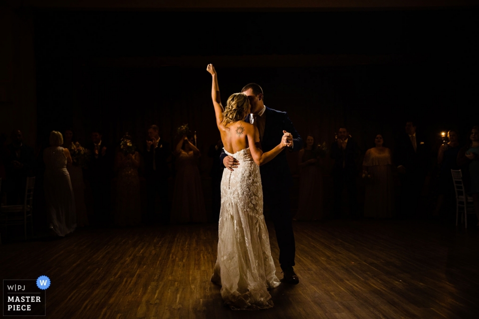 Foto di ricevimenti per matrimoni da The Old Mill in Rose Valley, PA | La sposa ha alzato la mano nella vittoria durante il primo ballo.