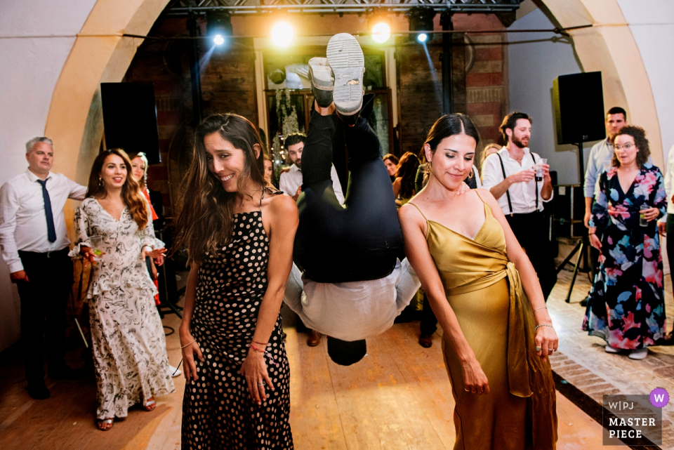 Villa di Montefreddo gasten die betrokken zijn bij gekke dansen met 60s muziek op de achtergrond - Bruiloftsreceptie dansfoto.