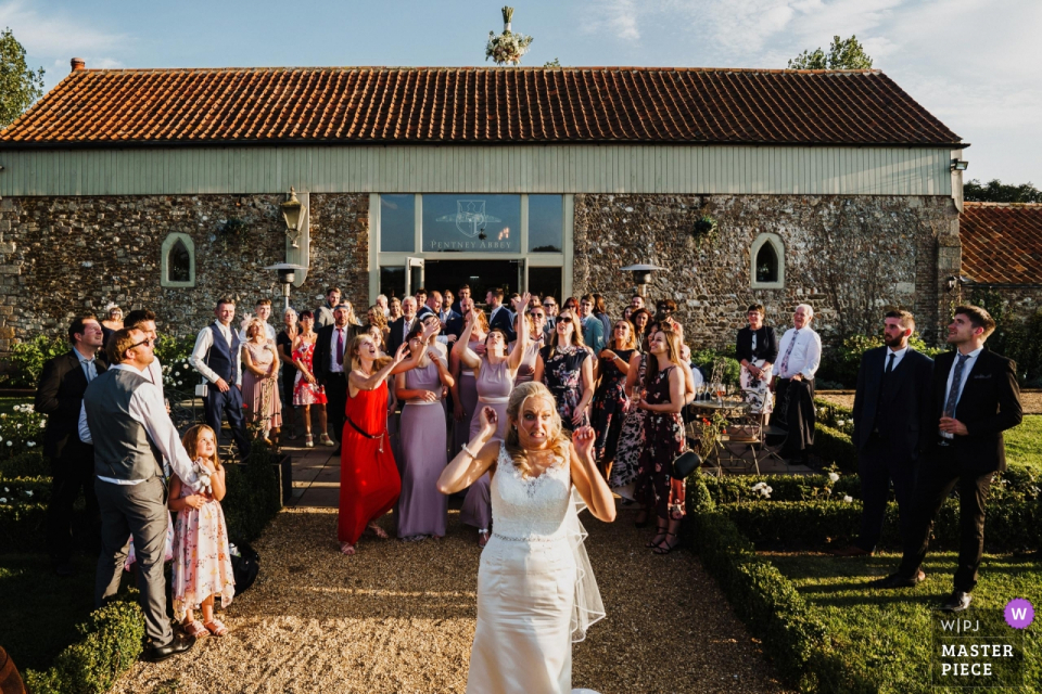 The bride is scared she has thrown her bouquet too high The bride is scared she has thrown her bouquet to high at Penteny Abbey, Norfolk - wedding pictures