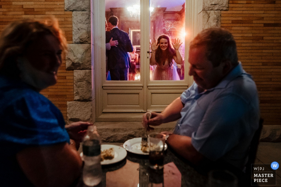 Cairnwood Estate, Huntington Valley, Pensylwania — Podczas przyjęcia wyszedłem na patio, aby uzyskać inną perspektywę. Widziałem dwóch gości cieszących się pustynią i obserwujących taniec przez okno. Gdy miałam zrobić zdjęcie, podeszła panna młoda