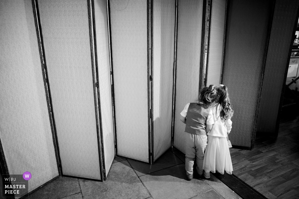 Square Tower, Portsmouth, UK wedding reportage: Page boy and flower girl sneak a peek of the bride