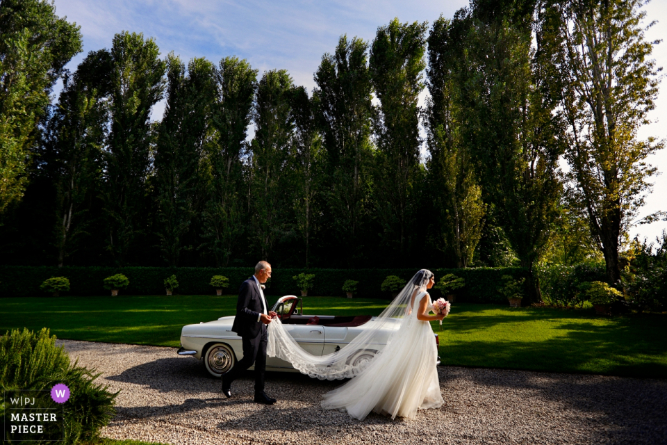 Photo: <a href="https://www.wpja.com/contests/2019-v20/best-wedding-photographers/2576076"> Danilo Coluccio - Siderno Reggio Calabria </a> Convento dell'Annunciata, Medole, Mantova | La mariée passe devant la voiture et vers l'église.