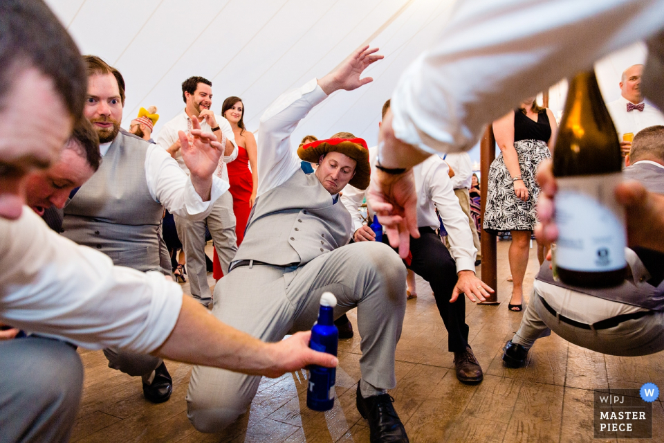 Un garçon d'honneur danse lors d'un mariage French's Point, Stockton Springs Maine photos du lieu de mariage | Un garçon d'honneur danse lors d'un mariage dans le Maine.